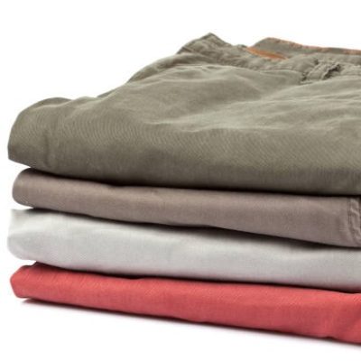 Neatly folded stack of mens chino pants with labels